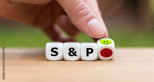 Better mood at the stock marked. Hand is turning a dice and changes a angry emoji to a happy emoji symbolizing a better mood at the stock marked S&P photo