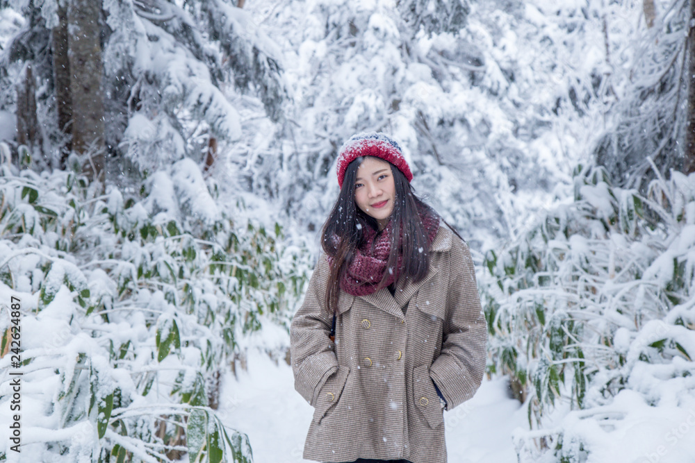 Portrait of woman with red wool hat feeling very happy and cold under snowy weather at Shin-hotaka, Japan Alps.