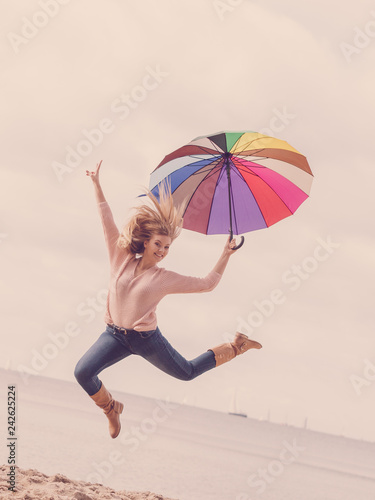 Funny woman jumping with umbrella