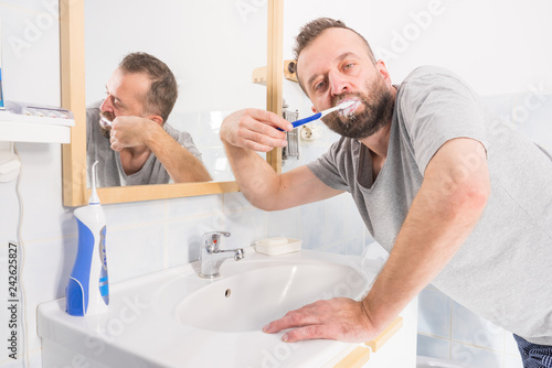 Man brushing his teeth in bathroom