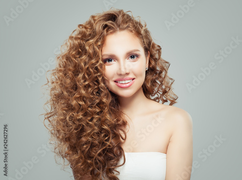 Smiling woman with long healthy curly hair background