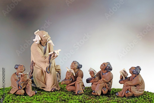 фотографія Learn China / Learn Chinese language and culture concepts : Clay sculptures of Confucius with students reading book