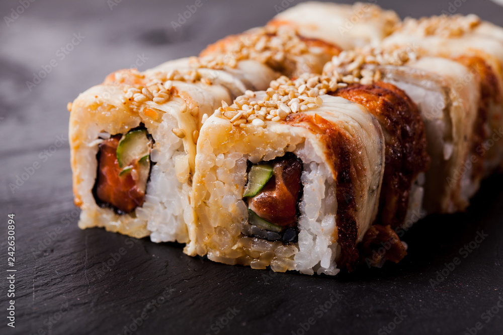 Unagi sushi roll on black slate board Unagi sushi roll on black slate board