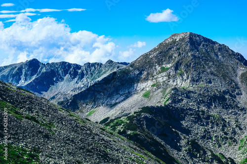 Beautiful alpine high mountains peaks, blue sky background. Amazing Mountain hiking paradise landscape, summertime.