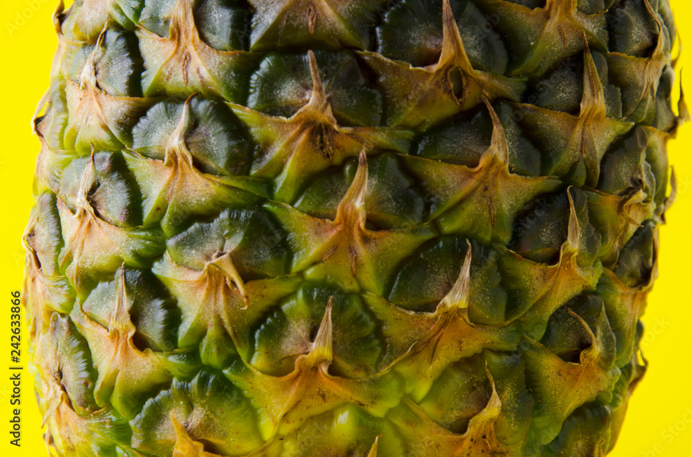 Closeup of pineapple peels against yellow background Closeup of pineapple peels against yellow background