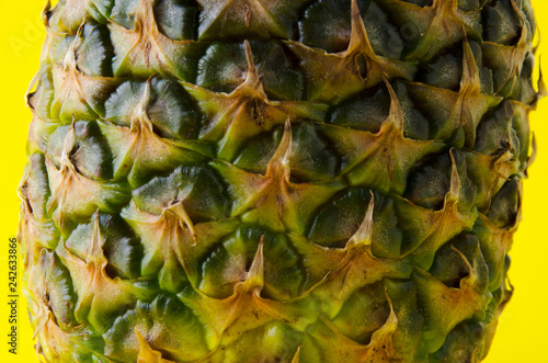 Closeup of pineapple peels against yellow background