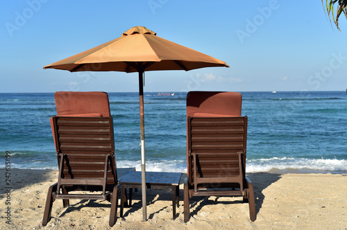 Lounge chairs with sun umbrella on the Sanur Beach  Bali  Indonesia