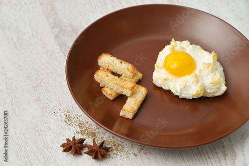 Orsini egg and croutons on a brown plate. photo