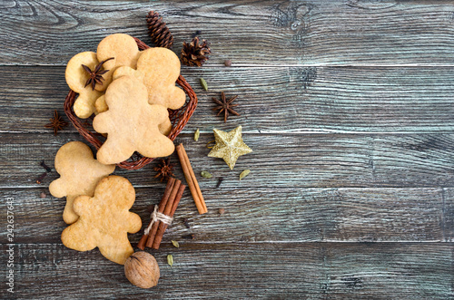 Ginger cookies on a wooden table with spices. Gingerbread men. The symbol of Christmas. Free space for your project.