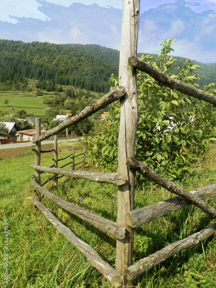 Landscape in central Slovakia - wooden fence in a meadow surrounded by mountains