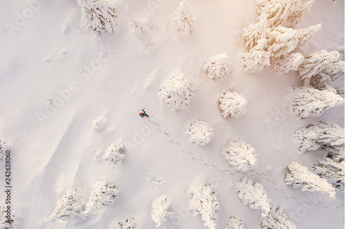 Sunny winter landscape with man on snowshoes  aerial view.