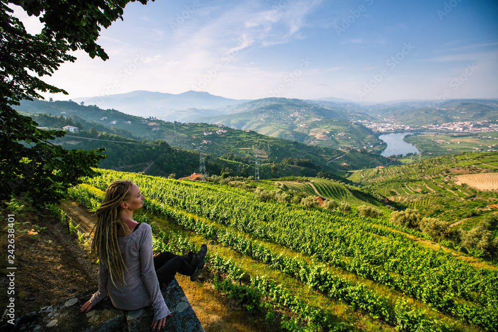 Woman on the viewing point of Douro Valley, Portugal. Top view of river, and the vineyards are on a hills.