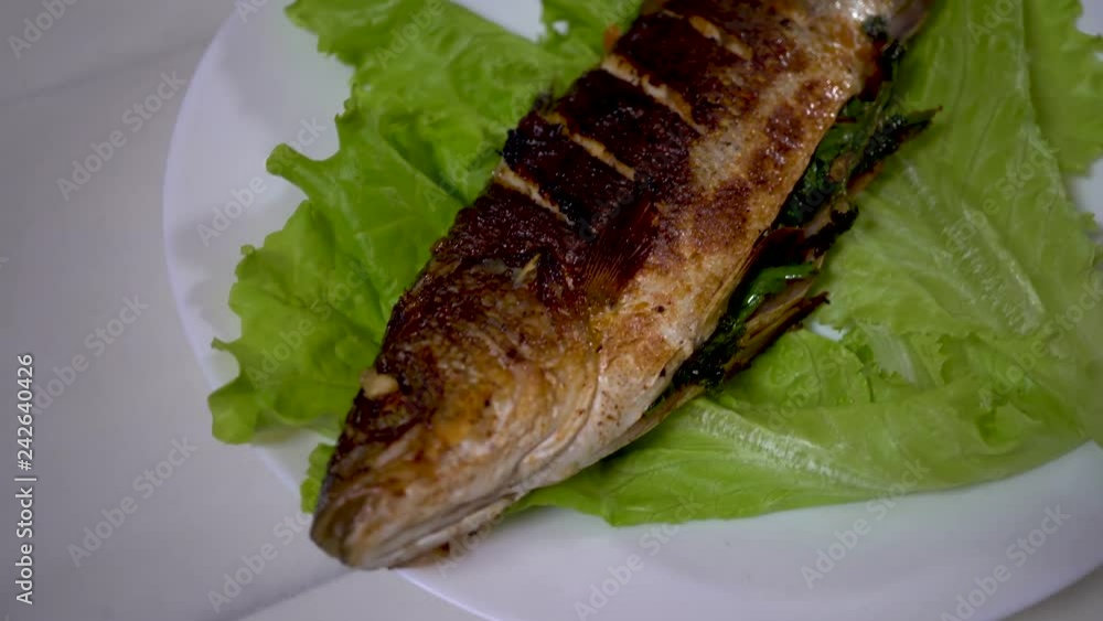 A chef cooks a Sea bass in frying pan.cooking concept. 4k, seafood