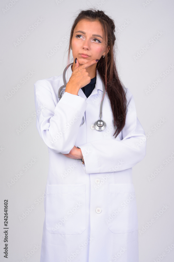 Young beautiful woman doctor thinking while looking up Young beautiful woman doctor thinking while looking up