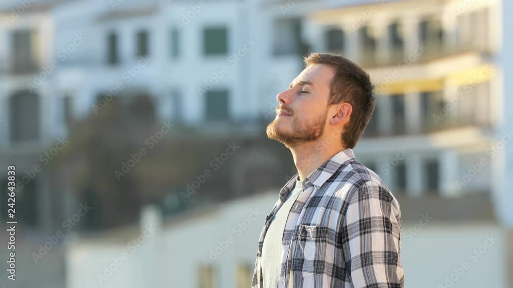 Side view portrait of a relaxed guy breathing fresh air in a town Side view portrait of a relaxed guy breathing fresh air in a town