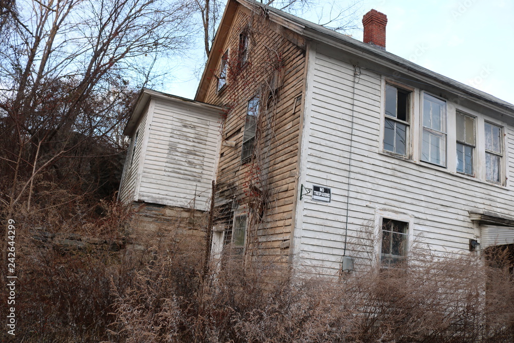 Old abandoned wooden weathered abandoned New England farmhouse 