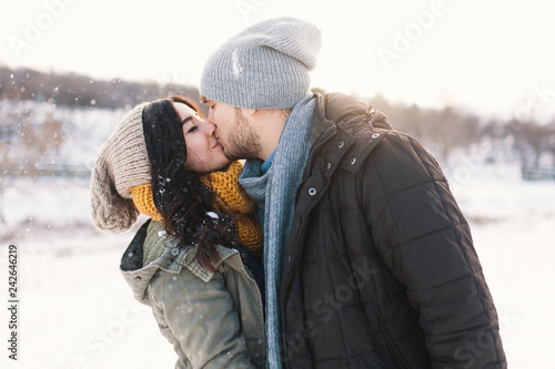 A happy young man and woman kissing in winter enjoying life and photo