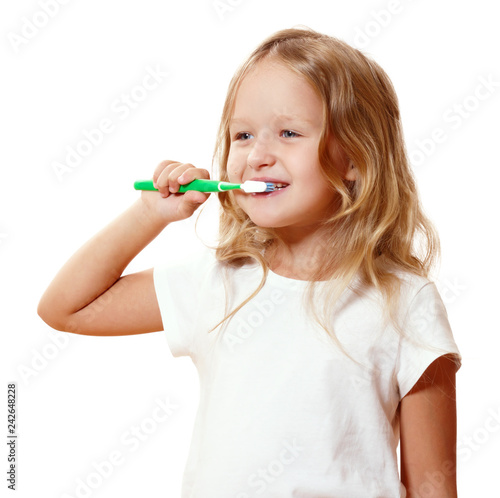 A little kid girl is brushing her teeth with a toothbrush. The concept of daily hygiene. Isolated on white background