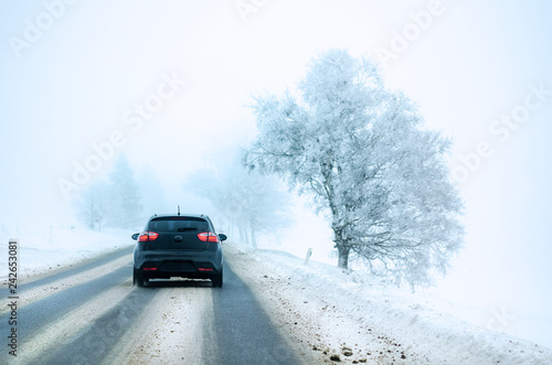 The car is driving through the snowy winter road. Cold weather in January and February.