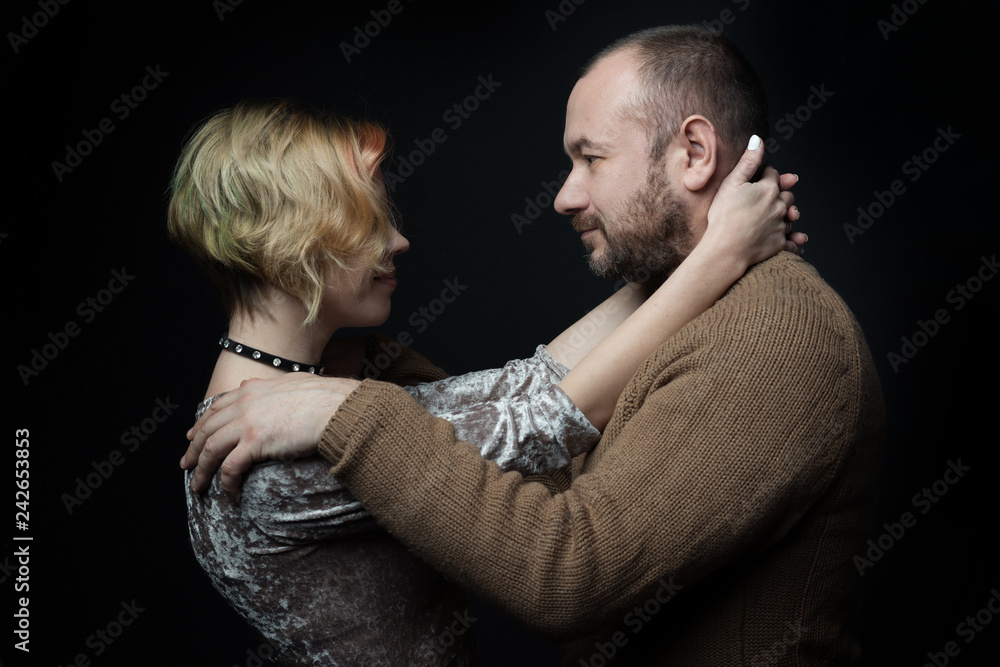 Romantic loving married couple 30-40 years old against a dark background. Romantic loving married couple 30-40 years old against a dark background.
