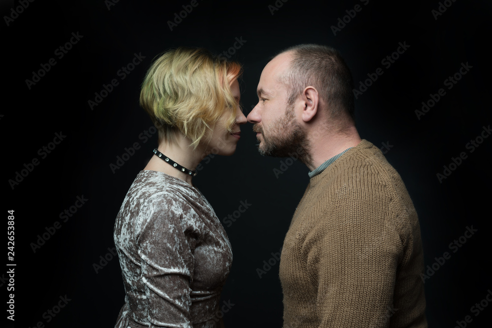 Romantic loving married couple, 30-40 years old, face to face against a dark background. Romantic loving married couple, 30-40 years old, face to face against a dark background.