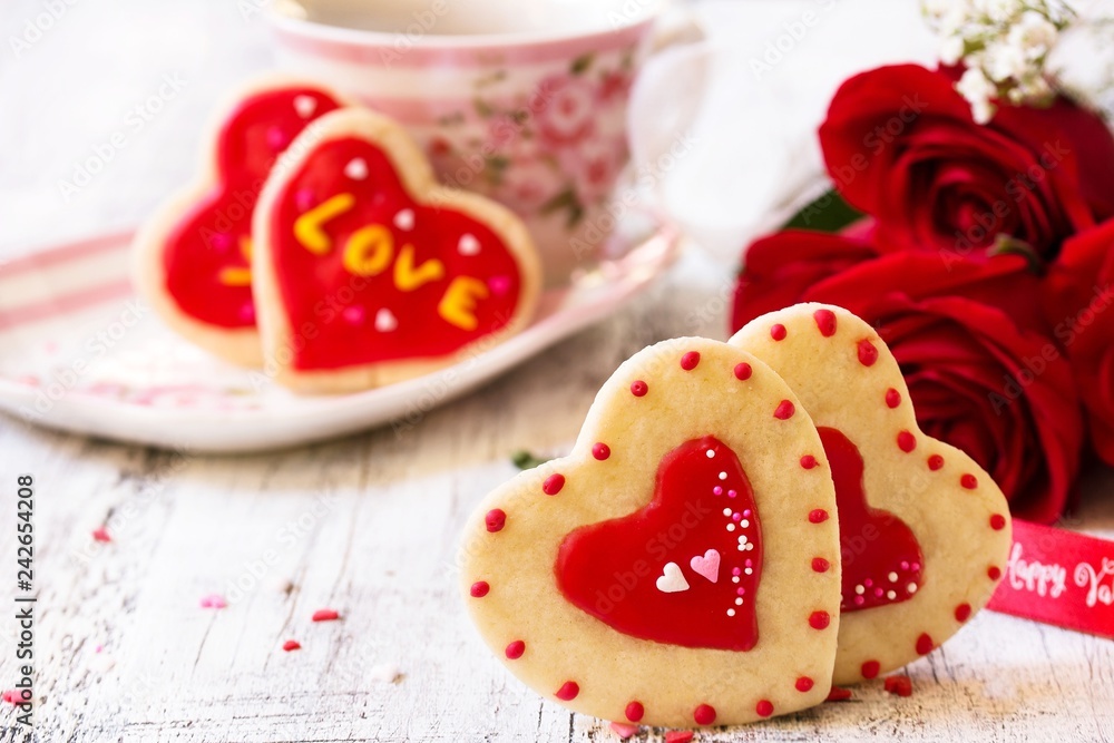 Homemade Valentines day heart cookies red roses on white rustic background Homemade Valentines day heart cookies red roses on white rustic background