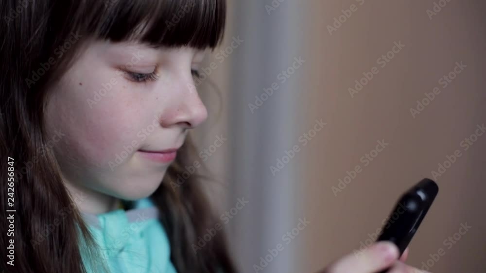 close-up portrait of a Caucasian teenage girl playing on a smartphone online game close-up portrait of a Caucasian teenage girl playing on a smartphone online game