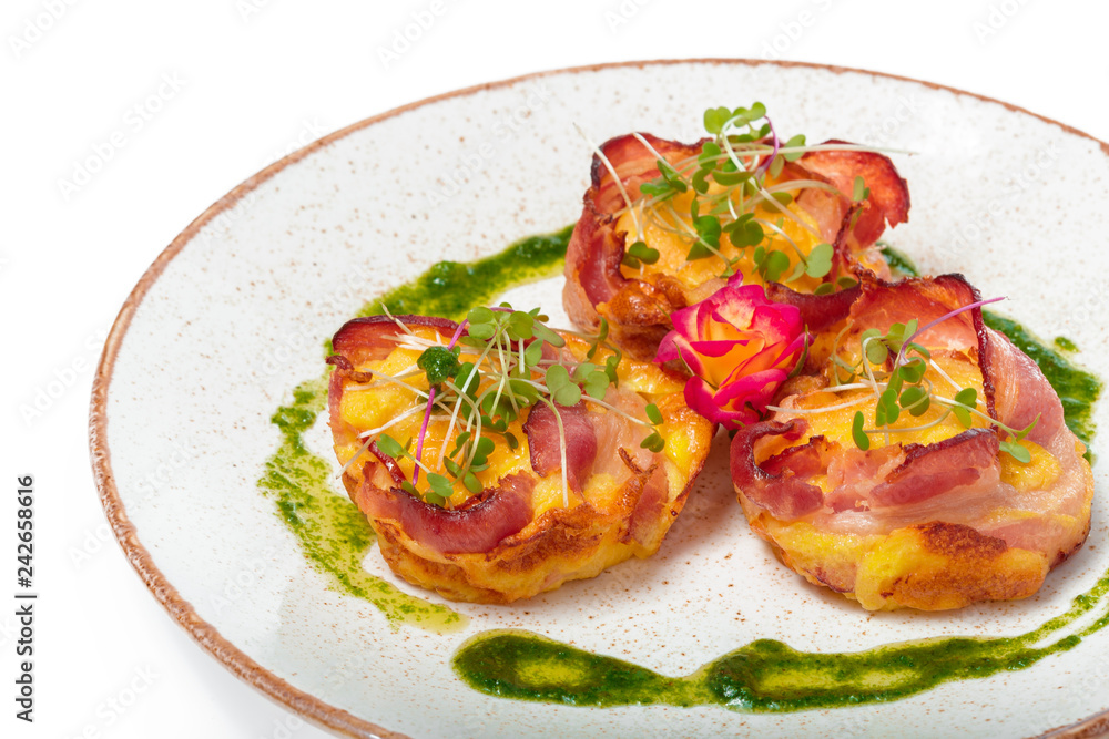 plate of bacon wrapped scallops in neat rows on a light colored plate