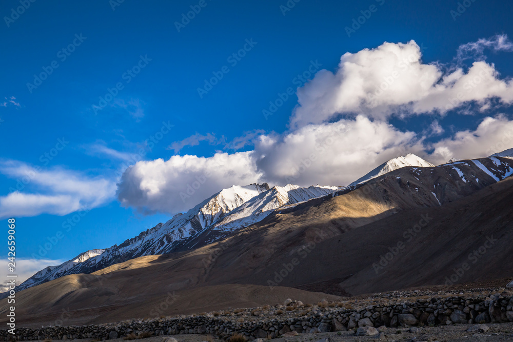 The early morning view with the sun ray casting a long shadow at the mountain range — at Pangong Tso.