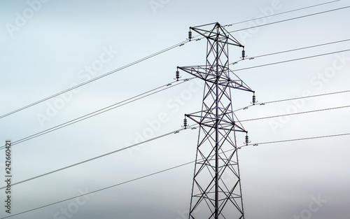 An electrical pylon against a grey overcast sky