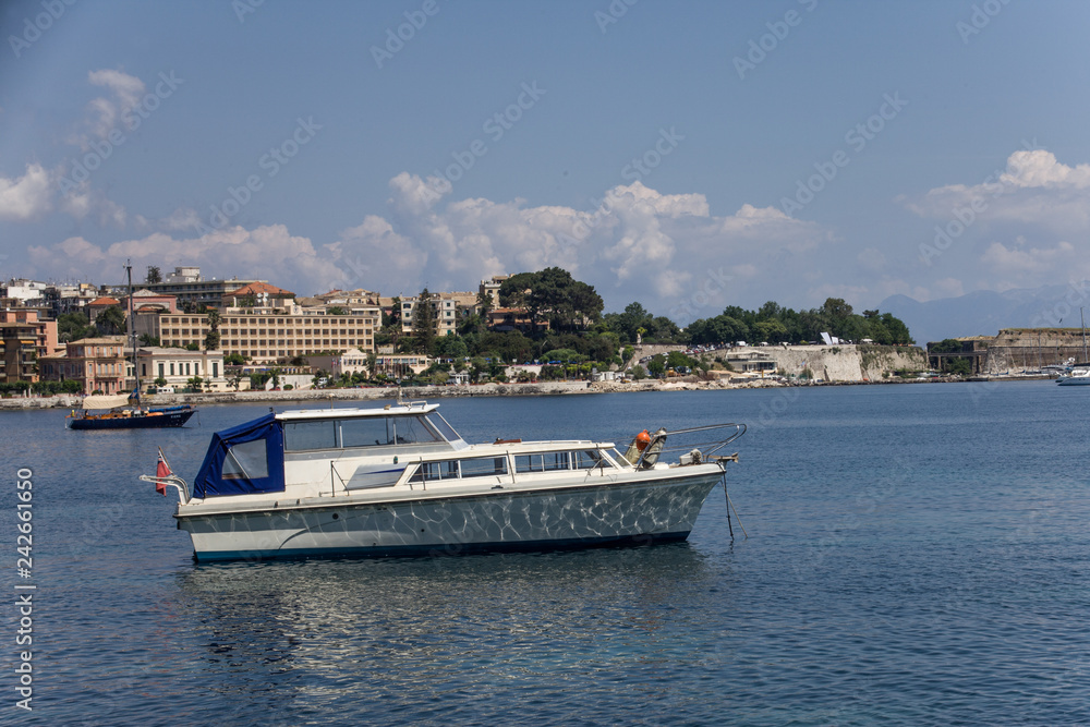 SideView Shot of Unmanned Double Deck Boat on Water under Cloudy Blue Sky. Establishments, Structures and Trees as Background. Vacation Destination Ideas