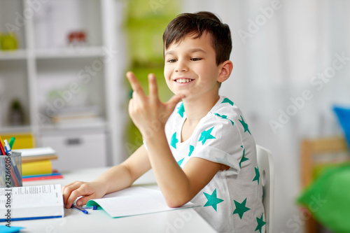 Quadro em tela education, childhood and school concept - happy student boy counting using finge