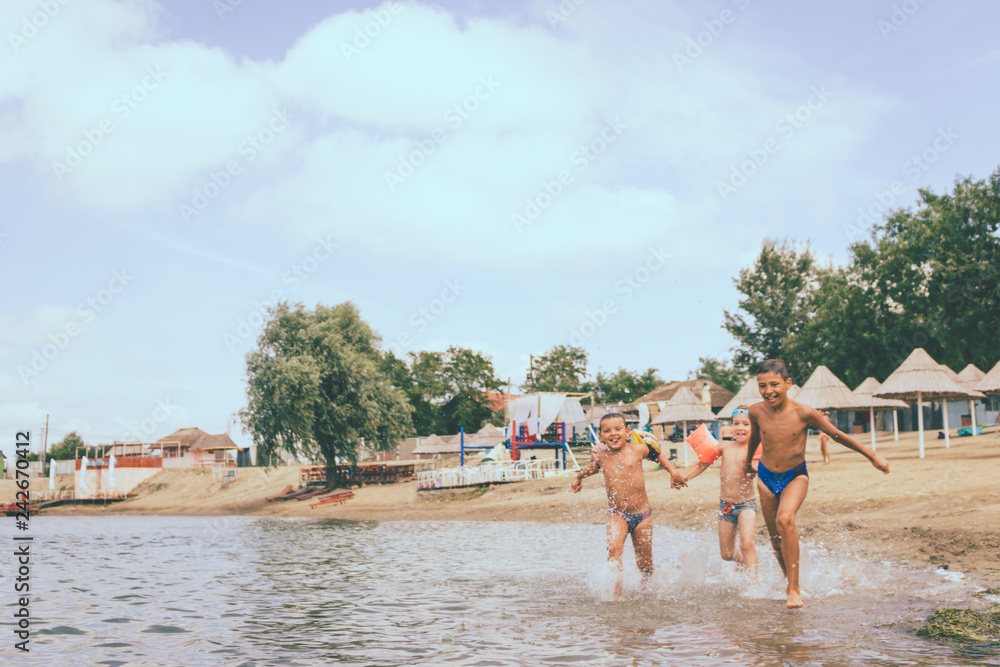 Playful kids running through water and having fun on the beach. Playful kids running through water and having fun on the beach.