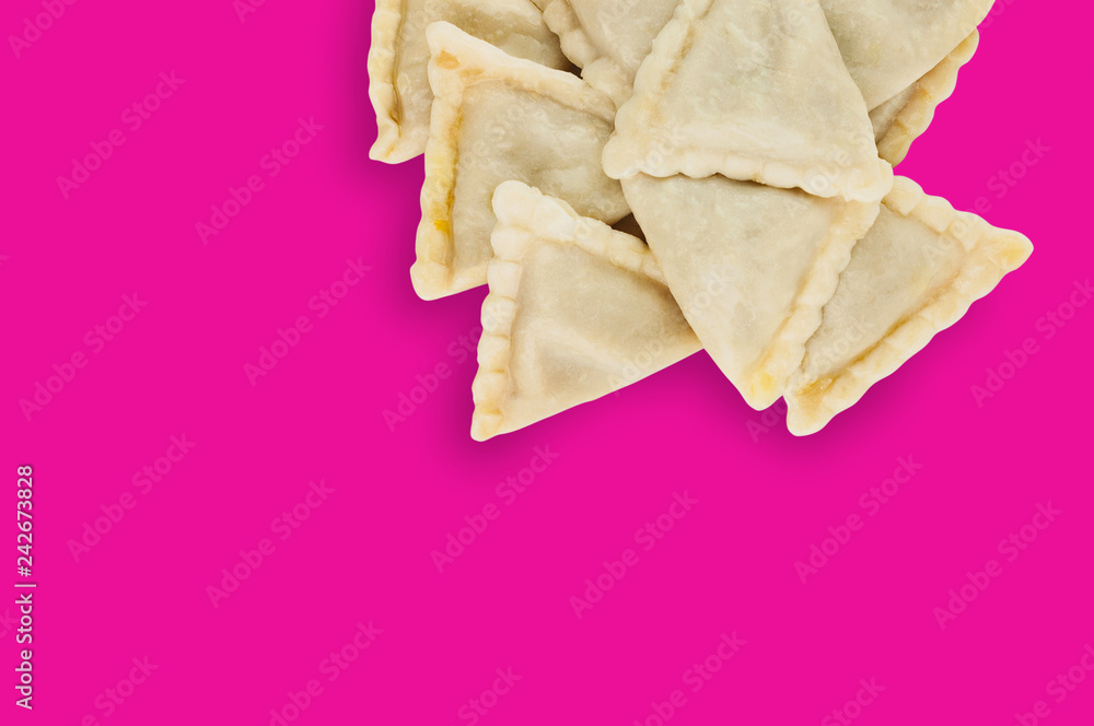 One heap of prepared vareniki with potato or cottage cheese or meat or cabbage on pink background with copy space for your text One heap of prepared vareniki with potato or cottage cheese or meat or cabbage on pink background with copy space for your text