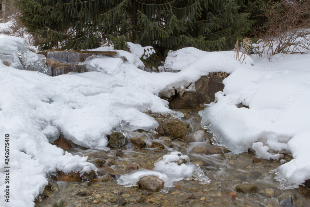 small frozen creek in a winter mountain landscape small frozen creek in a winter mountain landscape