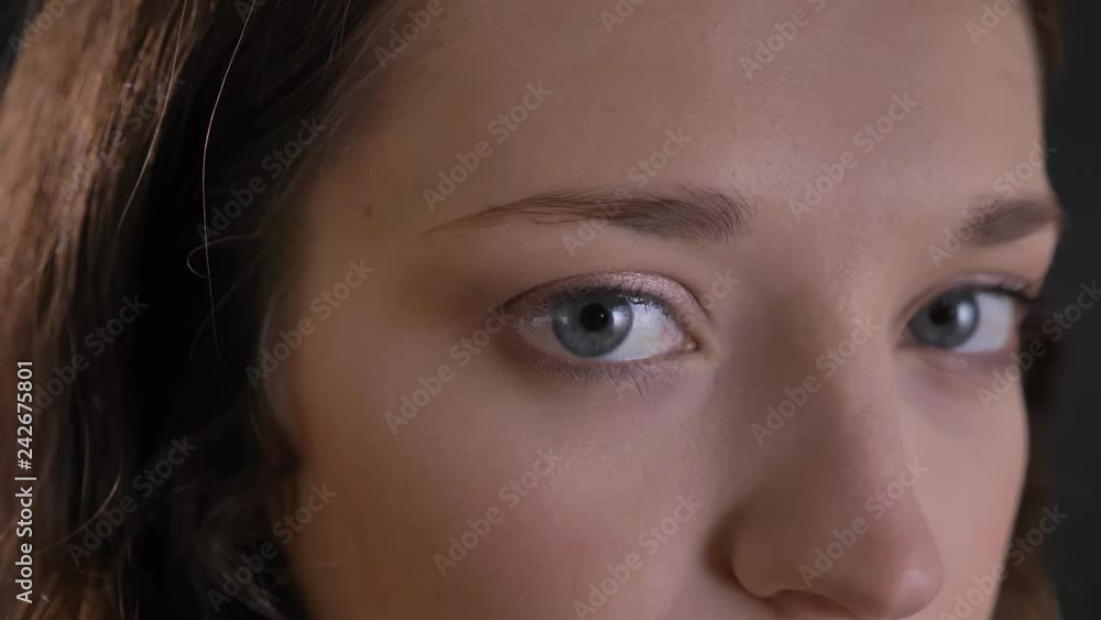 Close-up portrait in profile of caucasian long-haired girl watching calmly into camera and into distance on black background. Close-up portrait in profile of caucasian long-haired girl watching calmly into camera and into distance on black background.