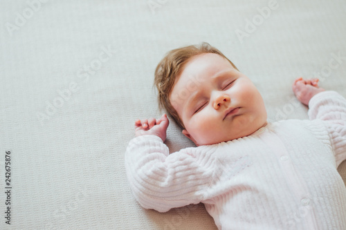 Infant baby sleeping on white sheets