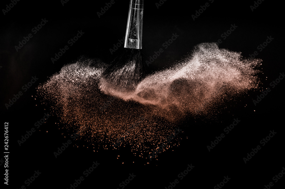 Fototapeta premium Living Coral Color of the year 2019, powder splash and brush for makeup artist or beauty blogger in black background