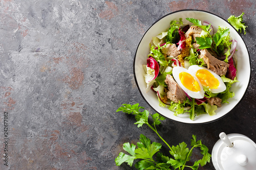 Diet food tuna salad with boiled egg, canned fish, onion and green lettuce top view