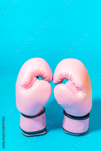 Pink boxing gloves isolated on blue background.