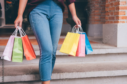 Consumer and shopping lifestyle concept, Happy young woman standing and holding colorful shopping bags enjoying great day in shopping