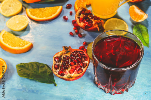 pomegranate juice and citrus fruits on a blue background.