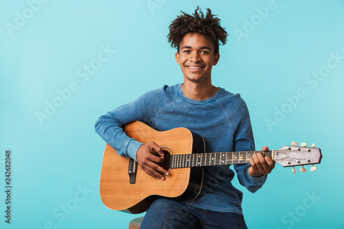Handsome young african man playing a guitar