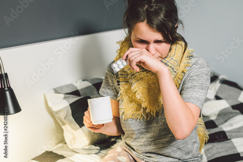 Bilde på lerret Young beautiful Caucasian woman has a cold, flu with high fever and heat at home in bed