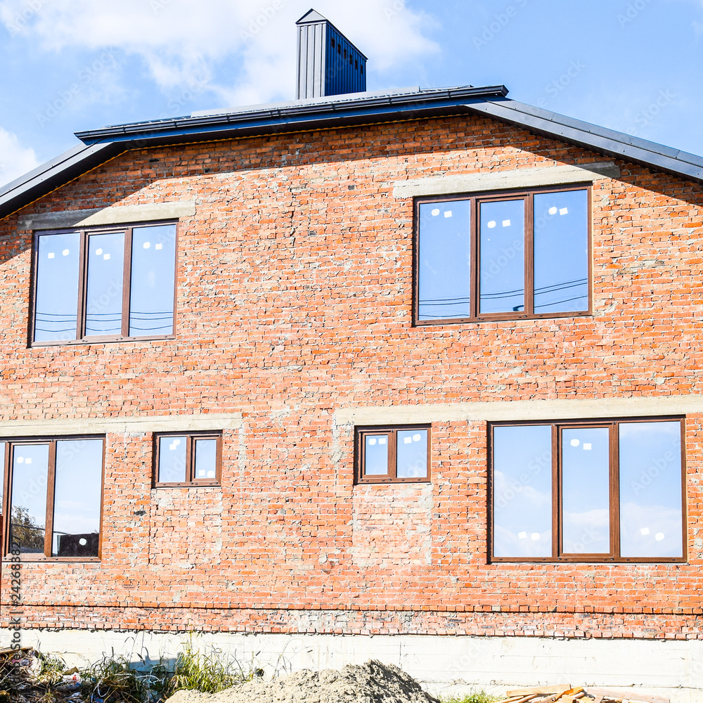 Two-storey house made of red brick. Metal-plastic windows. Newly