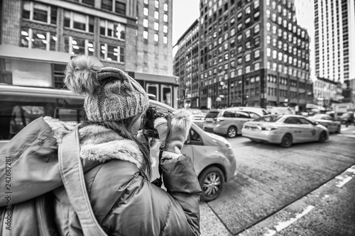 Female photographer taking pictures of New York Cabs in winter
