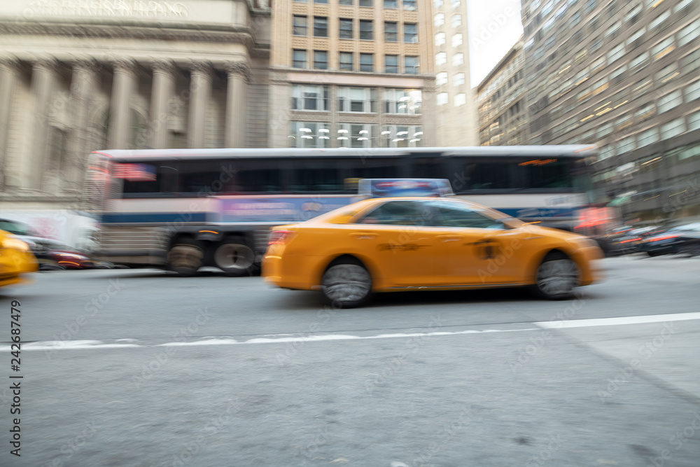 Blurred view of fast moving taxis and bus in Manhattan