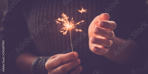celebration and event party concept closeup of pair of hands taking and using sparklers light fireworks and having fun - middle age woman celebrate birthday with lights