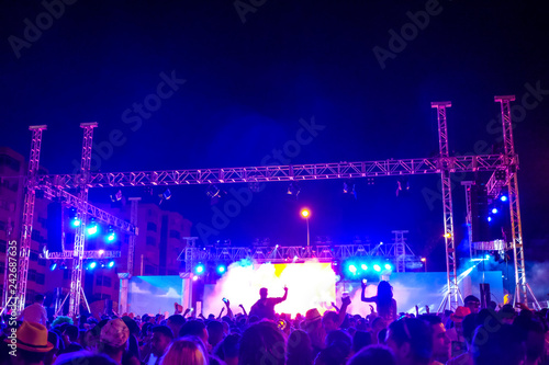 Live music concert with dj set and band in outdoor square by night - celebrate people crows having fun with party - group event with colors and lights - fun evening and disco