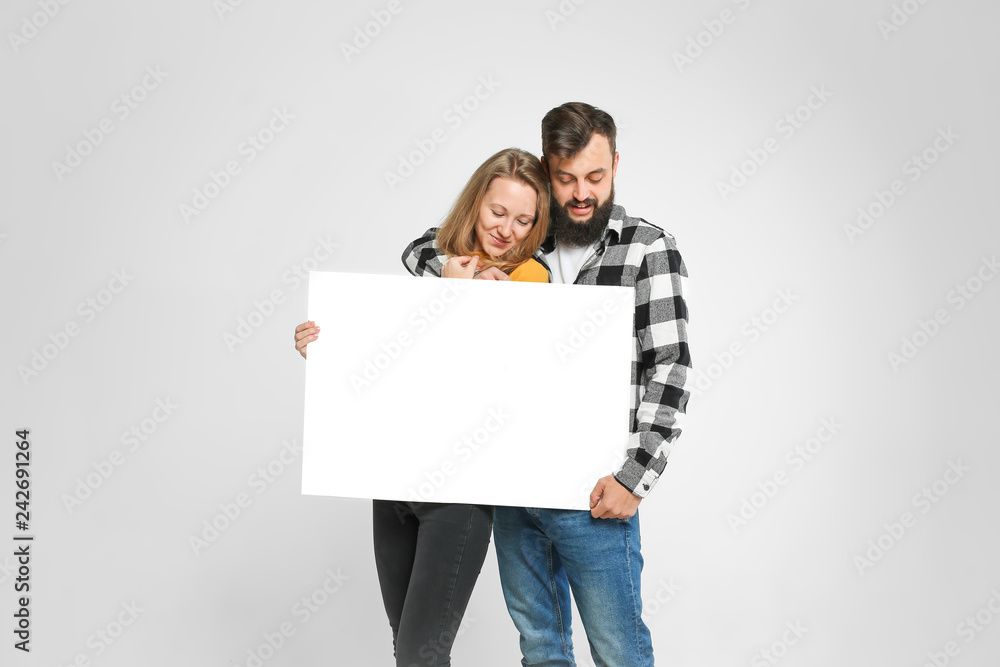 young loving couple, bearded man and blondie are smiling, hugging, holding blank banner, isolated on white background, Advertisement concept. Mockup for design young loving couple, bearded man and blondie are smiling, hugging, holding blank banner, isolated on white background, Advertisement concept. Mockup for design